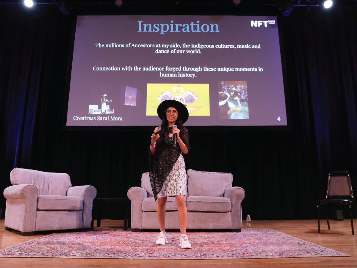 Creatress speaking on a stage at NFT.NYC with a slide titled Inspiration behind her