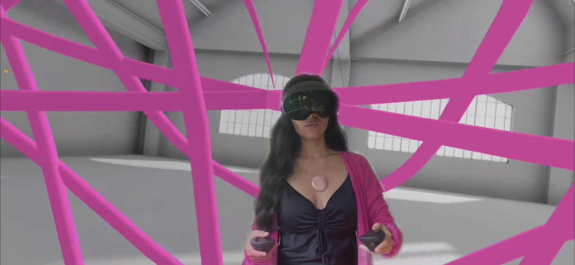 Creatress in a headset surrounded by pink ribbons of light in mixed reality